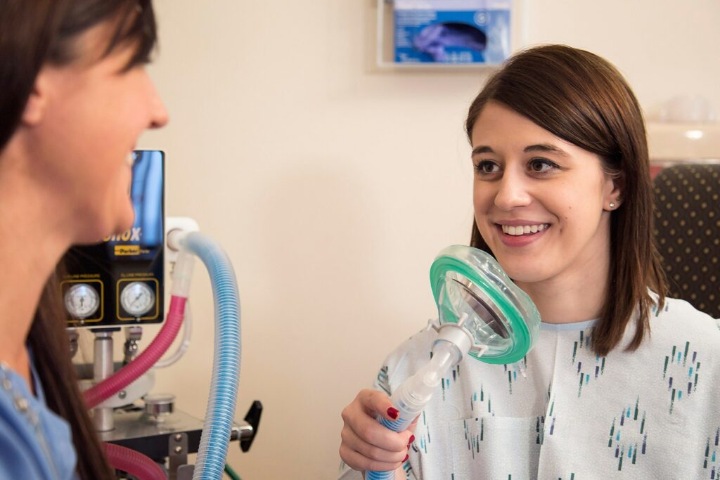 Patient smiling at nurse, learning about Nitrous Oxide during labor and delivery.