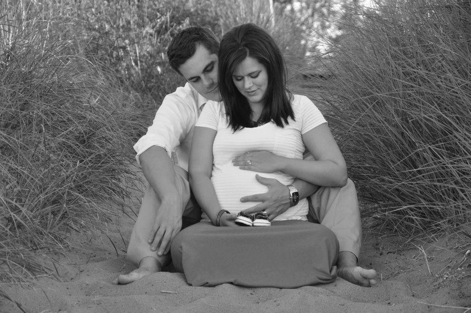 man and woman holding pregnant belly